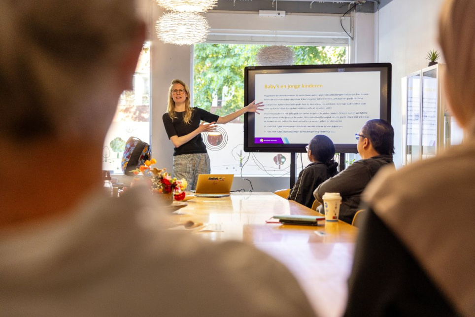 In de ouderkamer van de Flevoparkschool, één van de Amsterdamse familiescholen, wordt een bijeenkomst over mediawijsheid georganiseerd. 