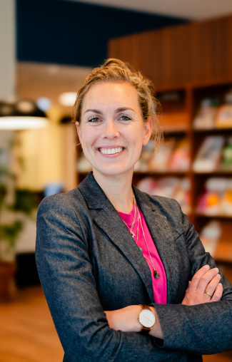Portret van leerkracht groep 4 en onderzoeker aan de Radboud Universiteit Hannah Bijlsma die met haar armen over elkaar de camera inkijkt - beeld bij artikel op aob.nl/onderwijsblad over de bekwaamheidseisen