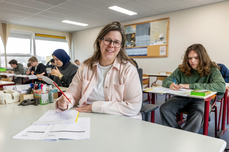 Een foto van docent Lisette Constandse die eindexamens nakijkt met rood potlood. Beeld bij artikel op aob.nl/onderwijsblad