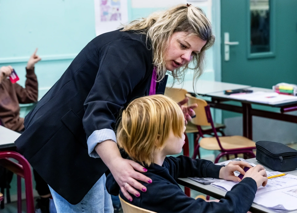 Teamleider en docent Frans, Karlijn Veltman spreekt een leerling bemoedigend toe. 