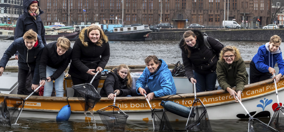 amsterdam-idee-docent-henk-winkelhuis-en-leerlingen-van-hettwents-carmel-college-uit-oldenzaal-vissen-naar-plastic-afval-op-een-bootje-van-plastic-whale