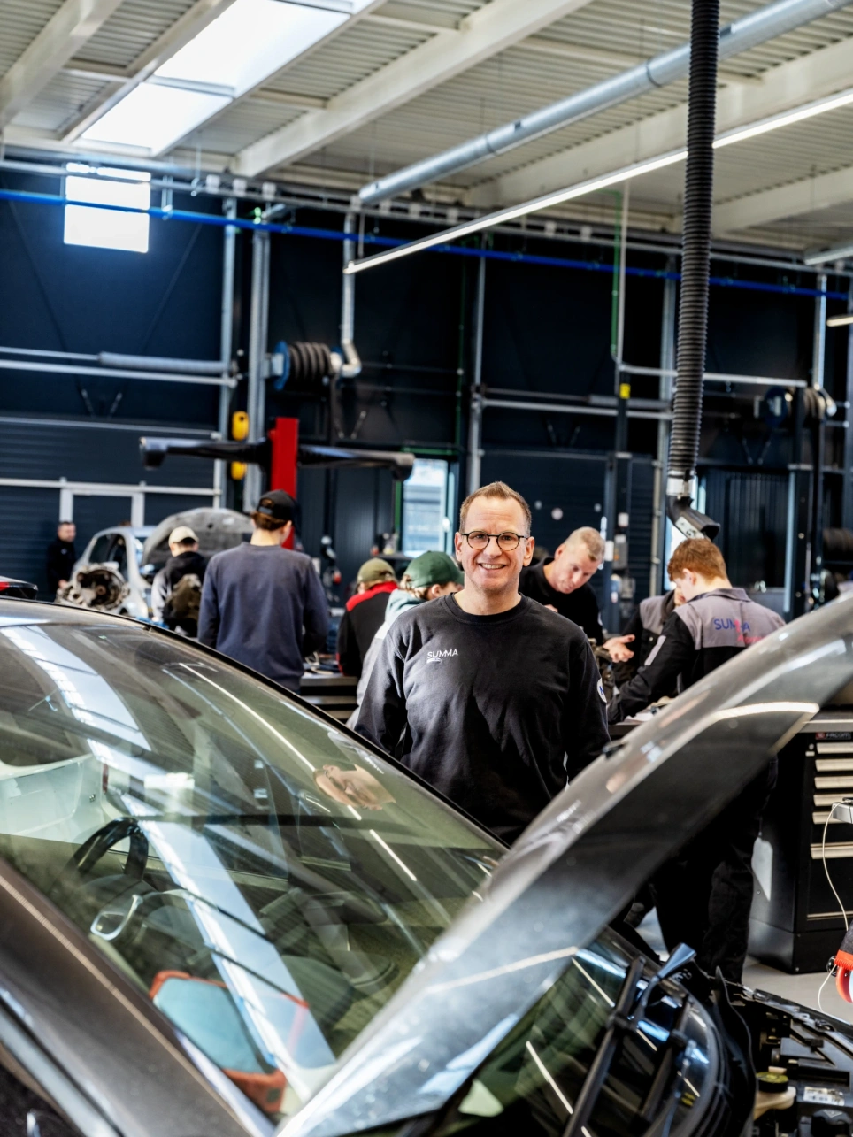 Een foto van practor Giel Kessels in een werkplaats met studenten. Beeld bij artikel op aob.nl/onderwijsblad