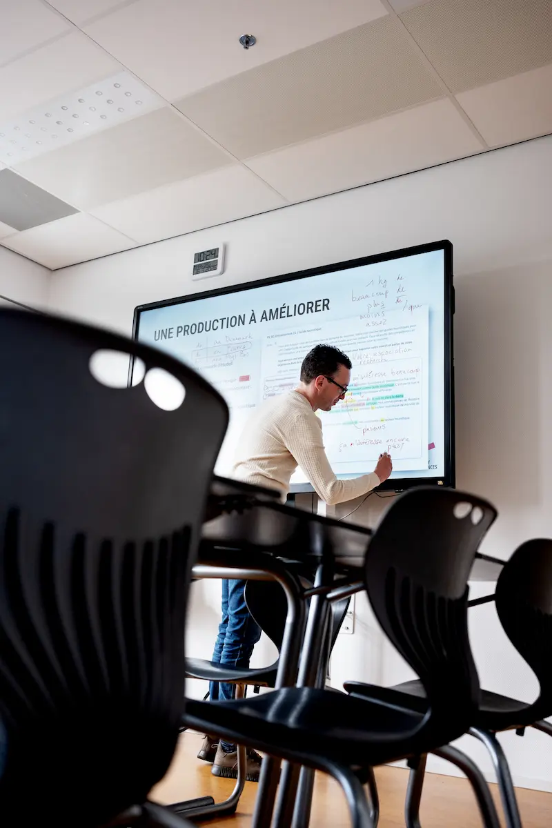 Lerarenopleider Frans Twan Geerts voor een digibord in een klaslokaal, afbeelding bij artikel op www.aob.nl