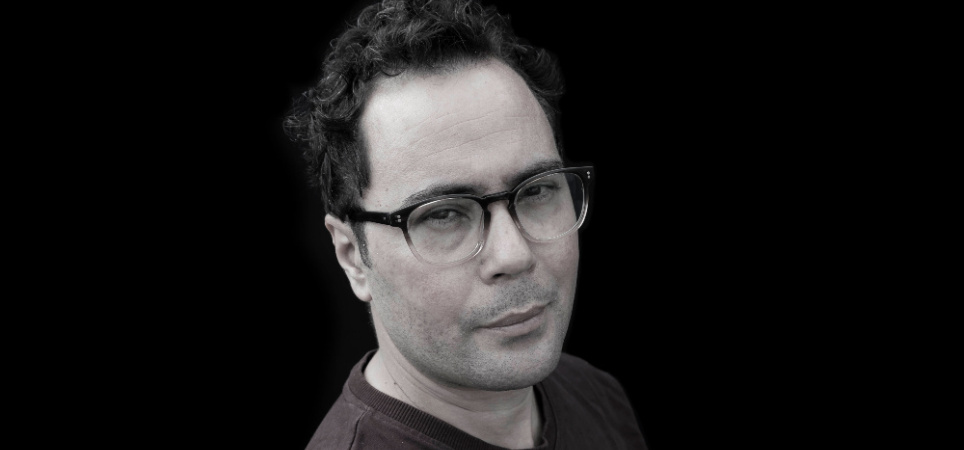 Foto Asis Aynan voor bij zijn column 1000x500