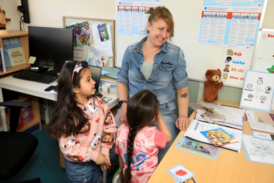 Portret van Siene Botter van basisschool de Achtbaan met twee leerlingen uit haar klas - beeld bij een artikel over taalvaardigheid op aob.nl/onderwijsblad