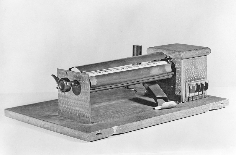 De testmachine van Sidney Pressey (1925). Cartoon van Wim Stevenhagen bij Onderwijsblad-verhaal over AI-gebruik in de klas. Beeld Smithsonian