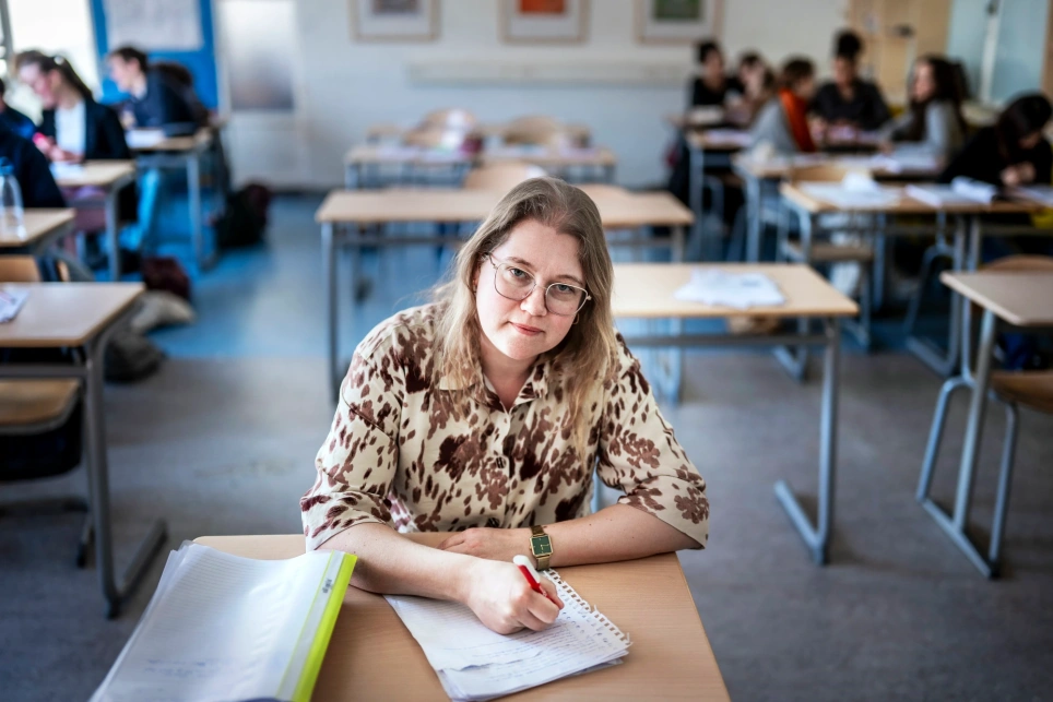 Een foto van docent Engels Tineke Lindeman, met een rood potlood aan haar bureau. Beeld bij artikel op onderwijsblad.nl/aob