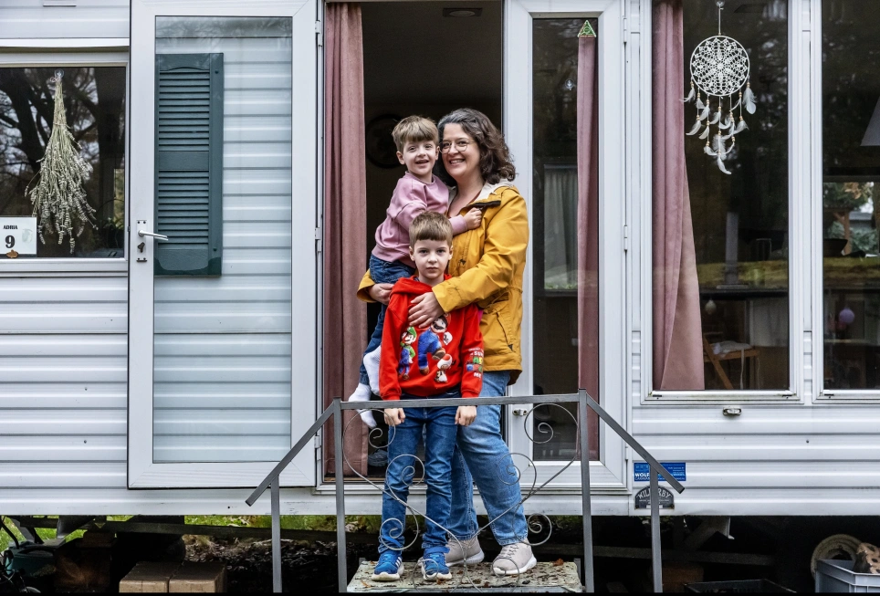 leraar met haar twee kinderen voor de caravan