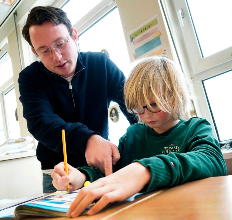 Een foto van oop'er Julian klein Bluemink met een kind uit zijn klas. Beeld bij artikel op aob.nl/onderwijsblad