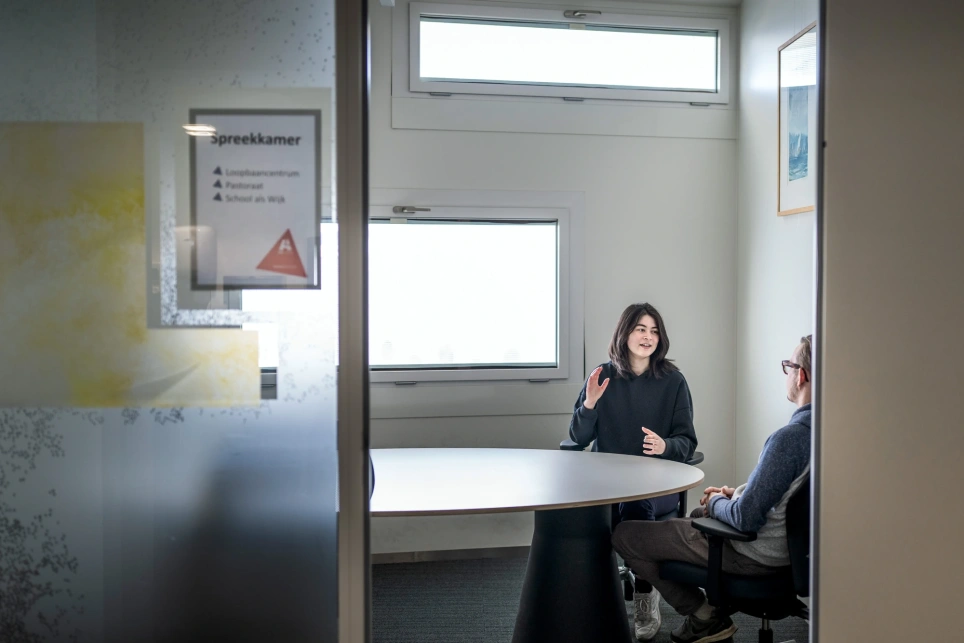 Leerlinge praat met pastor in spreekkamer